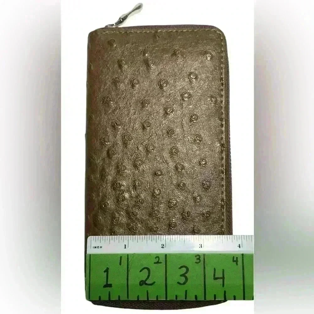 A woman’s brown wallet with ostrich leather print type pattern.